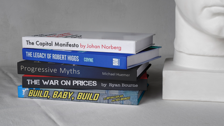 The five books featured in the article stacked on a desk beside a bust.