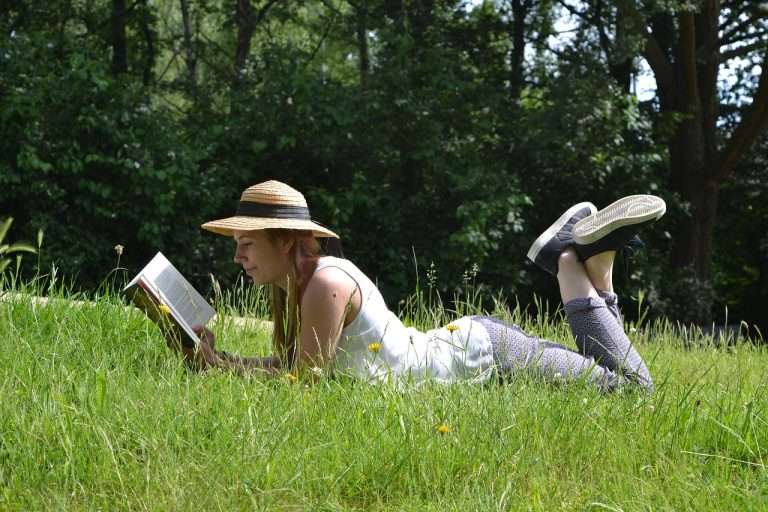 Girl reading while laying on the grass