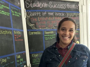 Shiren Rattigan in front of a blackboard.