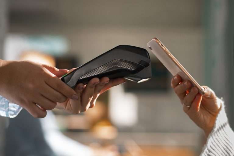 A person using a phone to make a contactless payment.