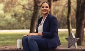 Giselle McClymont sitting on a picnic table in a park.
