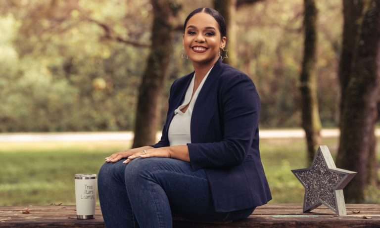 Giselle McClymont sitting on a picnic table in a park.