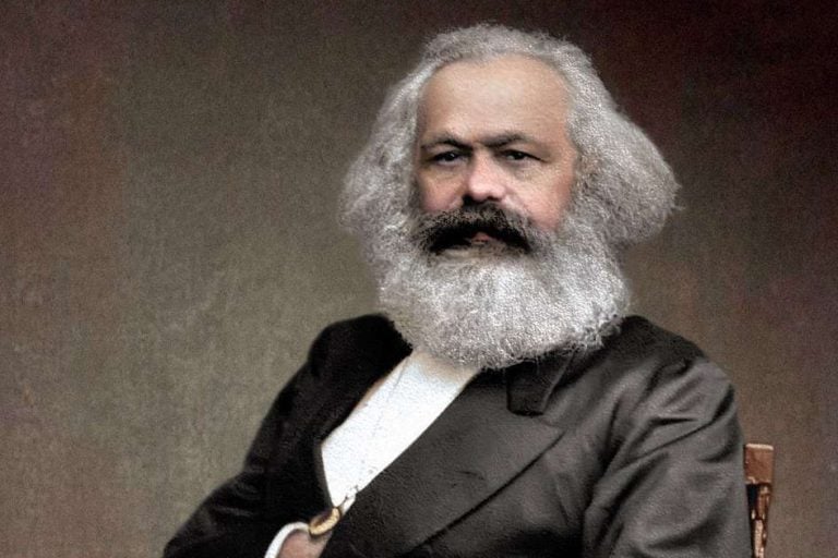 Karl Marx sitting in a chari.