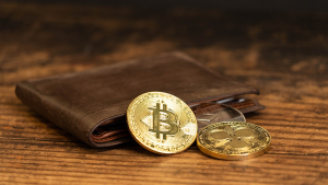 Wallet on a table with physical Bitcoin coins.