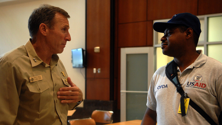 USAID worker talking with a soldier.
