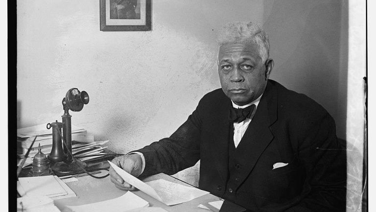 Oscar dePriest sitting at a desk.