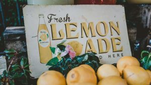 "Fresh lemonade" sign with lemons in front.