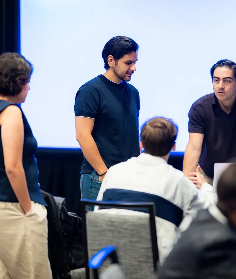 Students discussing around a table at a FEE event