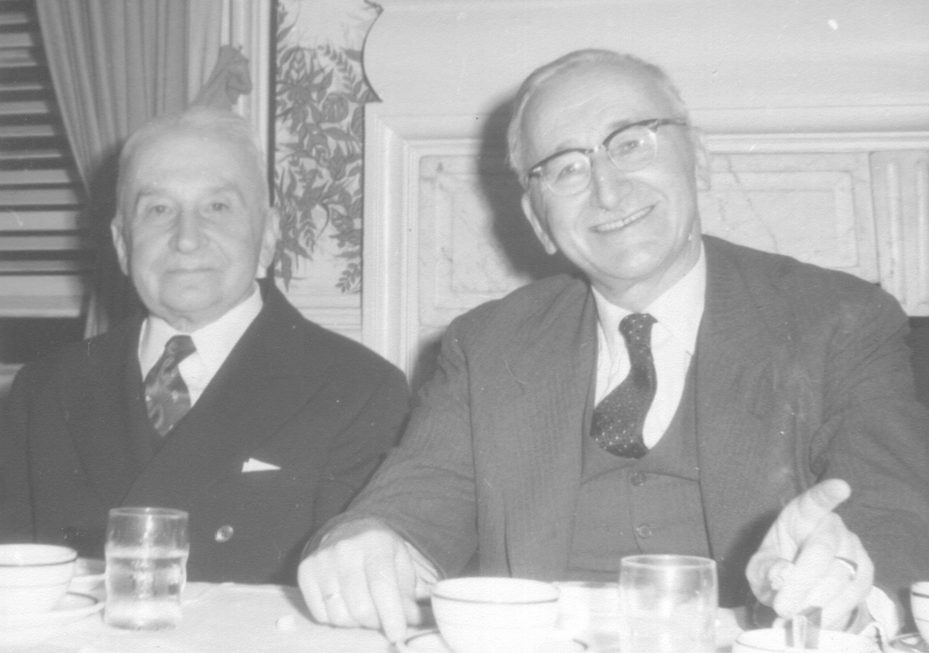 Two economists seated together at a luncheon