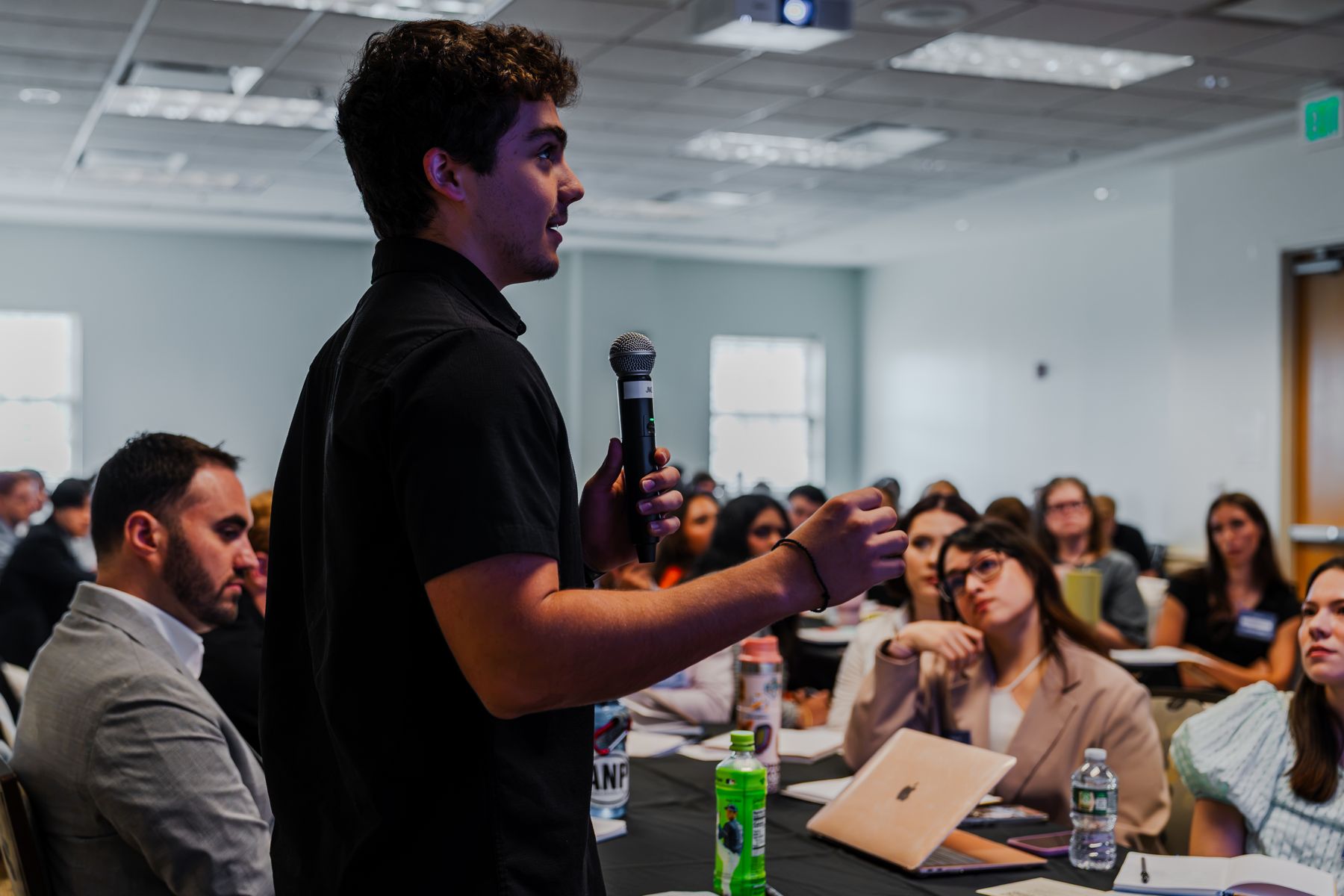 A student asking a question into a microphone at a FEE program